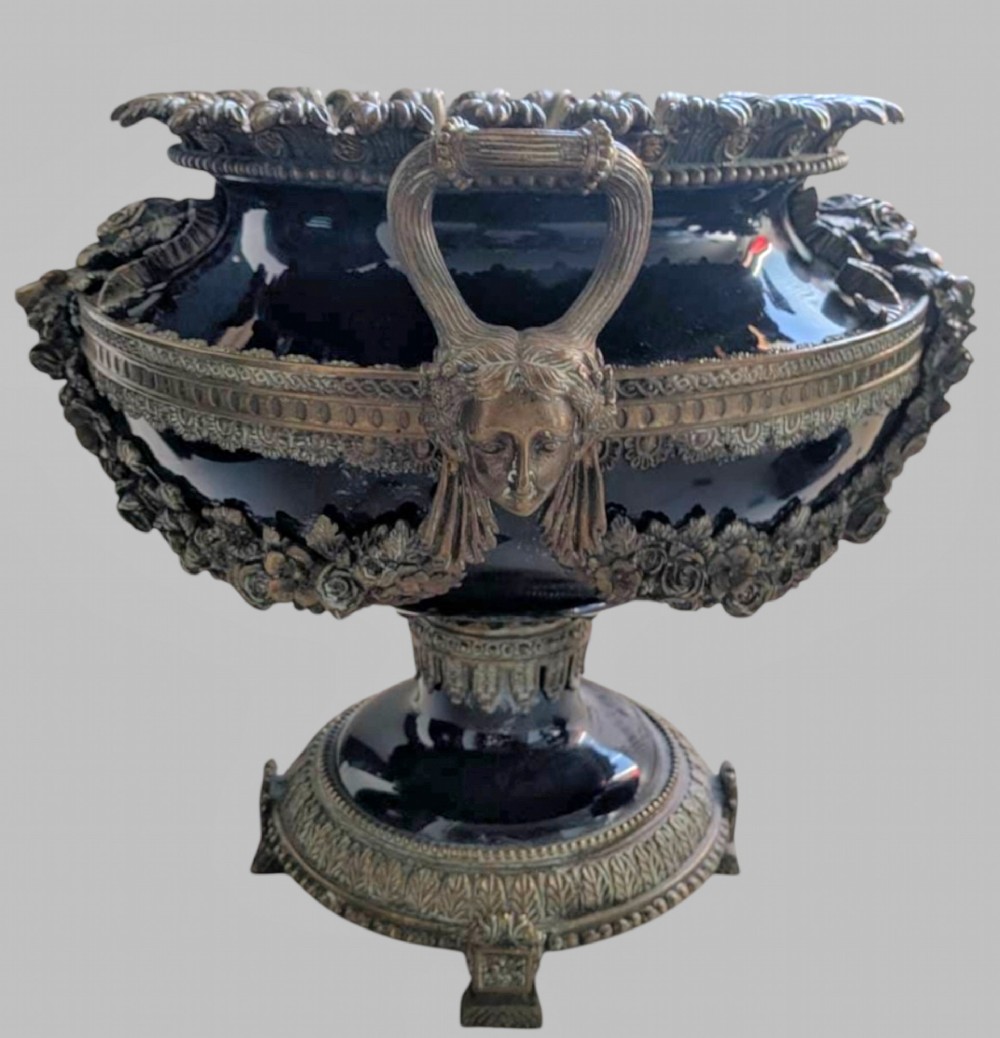 A pair of deep cobalt blue glazed ceramic urn-shaped jardinieres adorned with ornate gilt bronze mounts, floral swags, and decorative handles, set on footed bases. View III