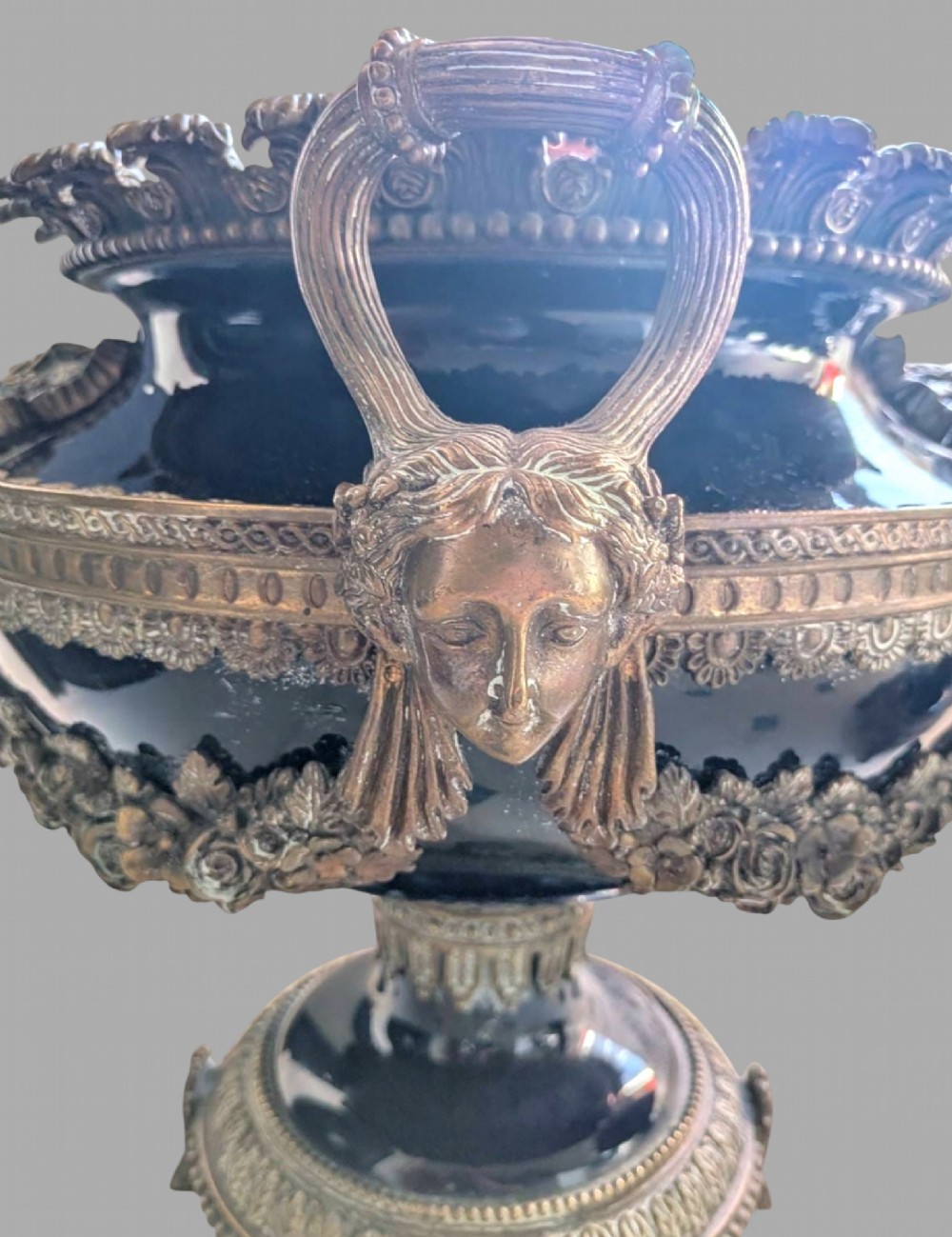 A pair of deep cobalt blue glazed ceramic urn-shaped jardinieres adorned with ornate gilt bronze mounts, floral swags, and decorative handles, set on footed bases. View IV