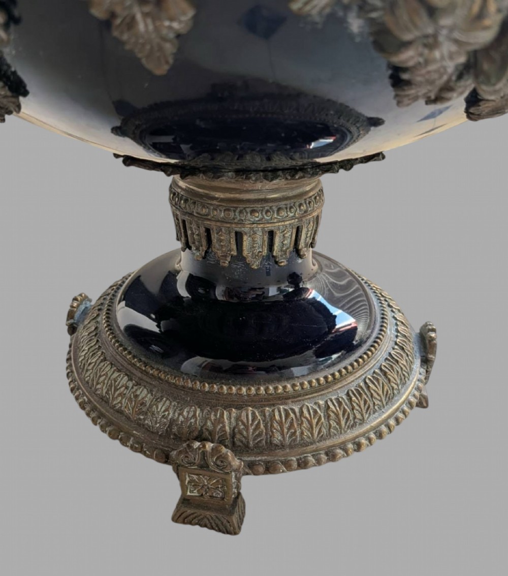 A pair of deep cobalt blue glazed ceramic urn-shaped jardinieres adorned with ornate gilt bronze mounts, floral swags, and decorative handles, set on footed bases. View VIII