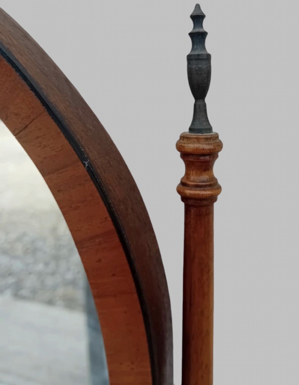 An Edwardian mahogany arched dressing table mirror featuring turned side supports with finials, brass adjustment knobs, and a curved base. View II