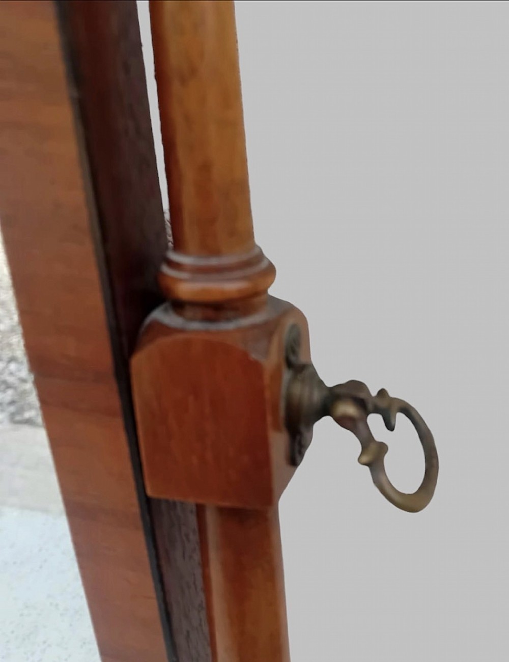 An Edwardian mahogany arched dressing table mirror featuring turned side supports with finials, brass adjustment knobs, and a curved base. View V