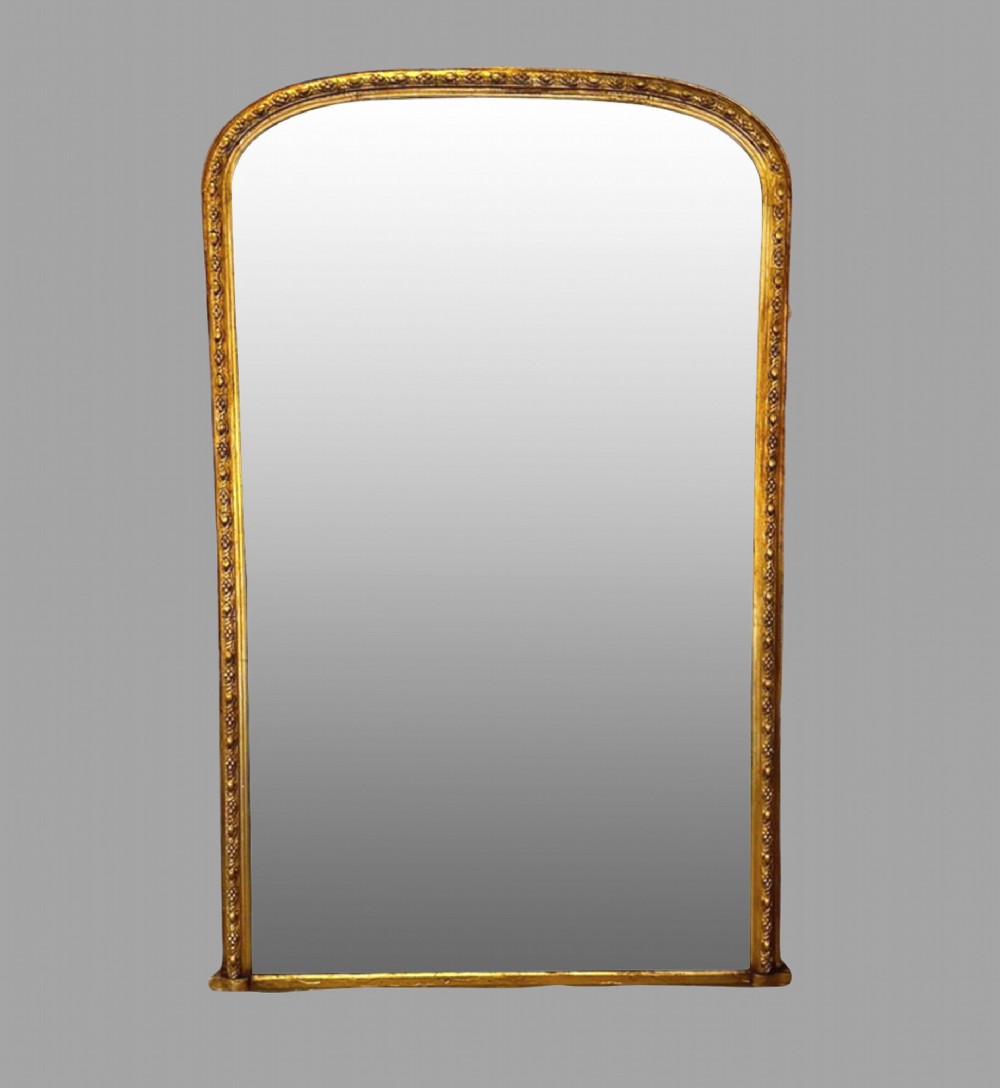 A large nineteenth-century giltwood pier mirror with an arched upper frame and beaded moulding detail.