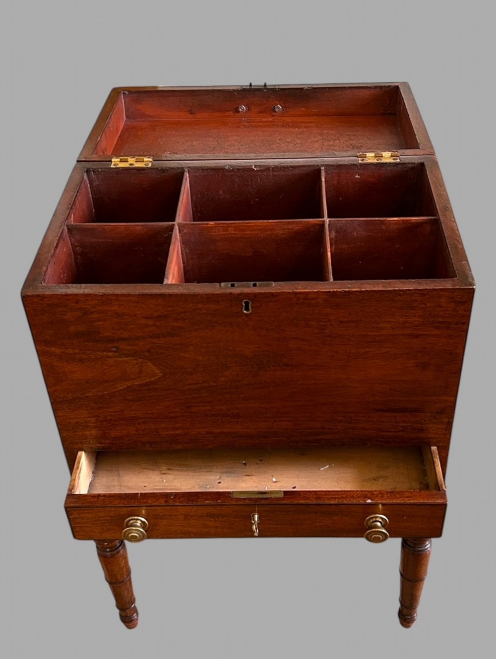 A Georgian mahogany wine cellarette featuring a hinged lid with a top brass handle, keyhole, lower drawer, and four turned legs. View II