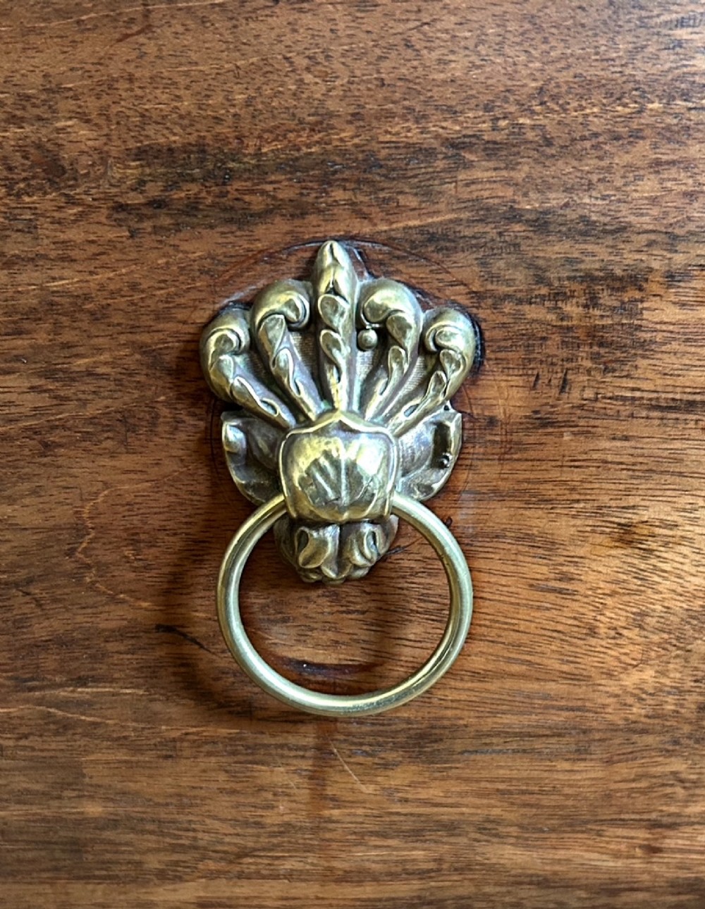 A Georgian mahogany wine cellarette featuring a hinged lid with a top brass handle, keyhole, lower drawer, and four turned legs. View V