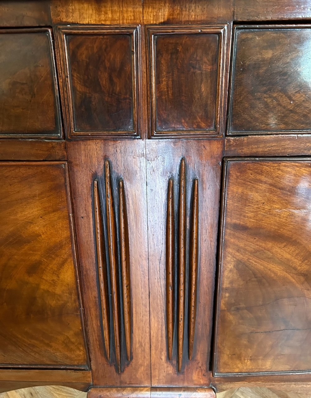 A 19th-century flame mahogany sideboard featuring two upper drawers, two cabinet doors, reeded pilasters, oval brass handles, a low gallery back, and carved paw feet. View VIII