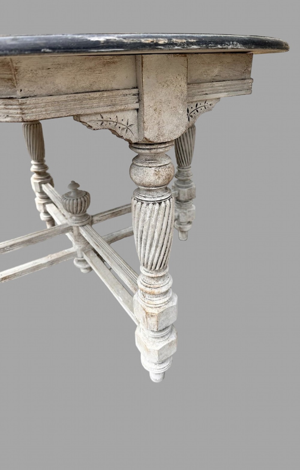 A late 19th-century round centre table with a dark top, distressed grey painted base, spiral turned legs, and an X-frame stretcher with a central finial. View II