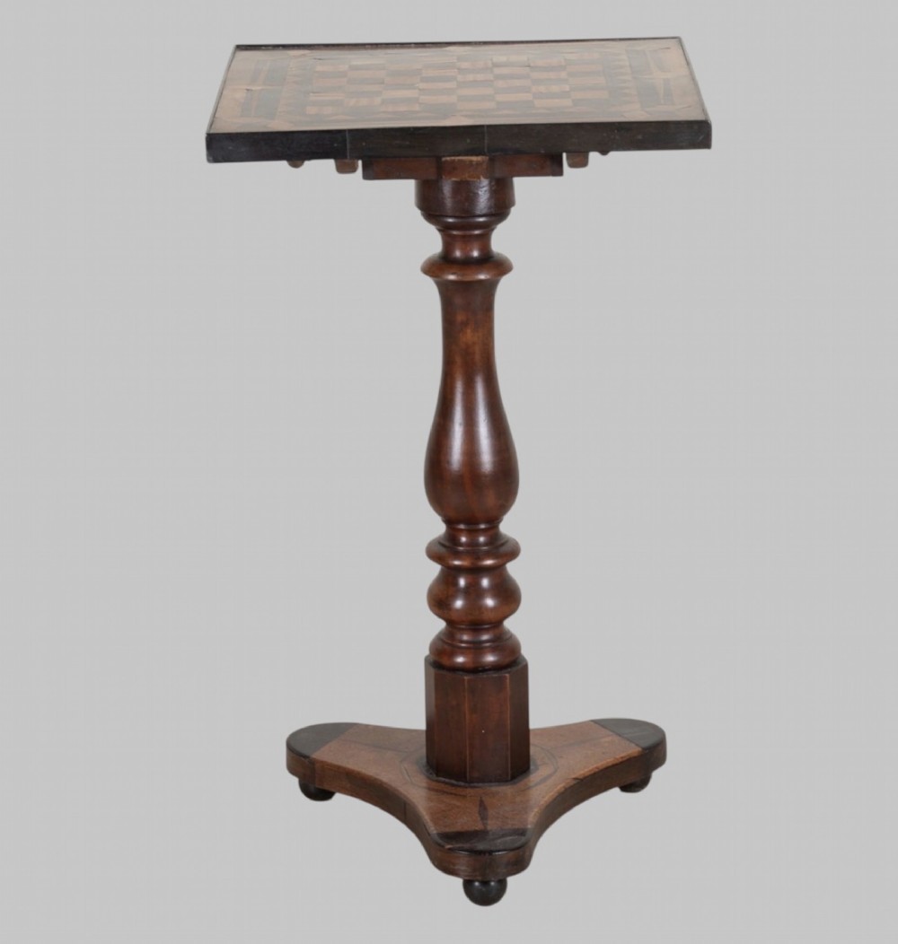 A Georgian tilt-top games table with a square geometric inlaid chessboard top mounted on a turned pedestal column and triform base with ball feet. View II