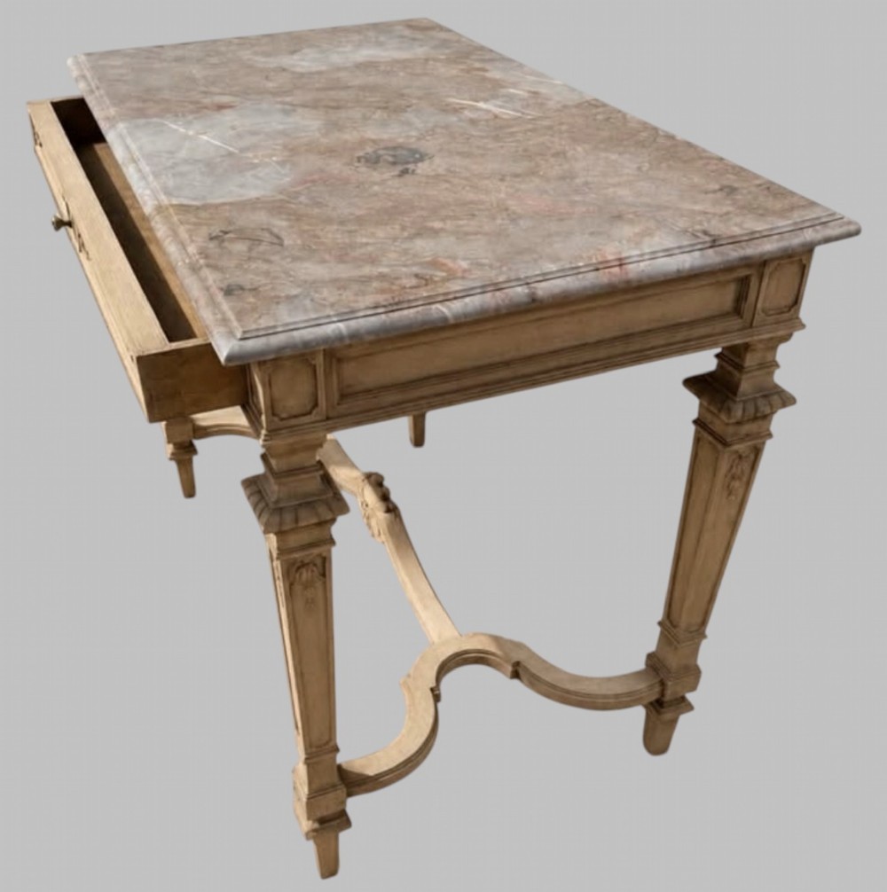 A late 19th-century French side table with a grey marble top, carved pale timber frame, single frieze drawer, and shaped central stretcher. View II