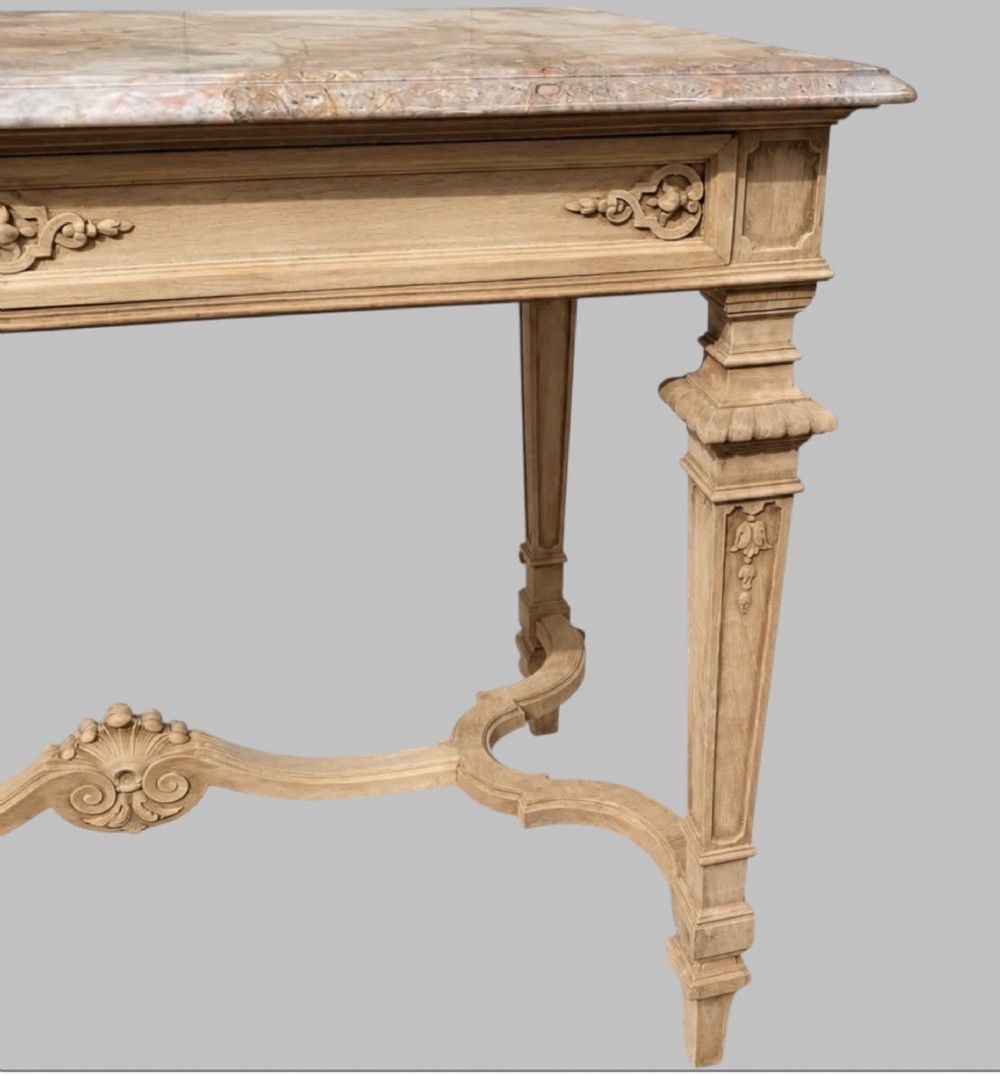 A late 19th-century French side table with a grey marble top, carved pale timber frame, single frieze drawer, and shaped central stretcher. View IV