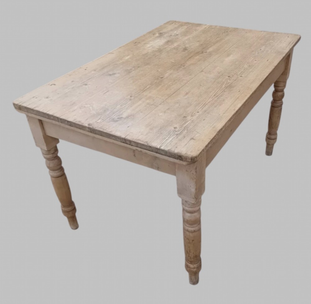 A late 19th-century rectangular pine farmhouse table featuring a scrubbed wood plank top, a frieze drawer with turned wooden knobs, and turned legs. View III