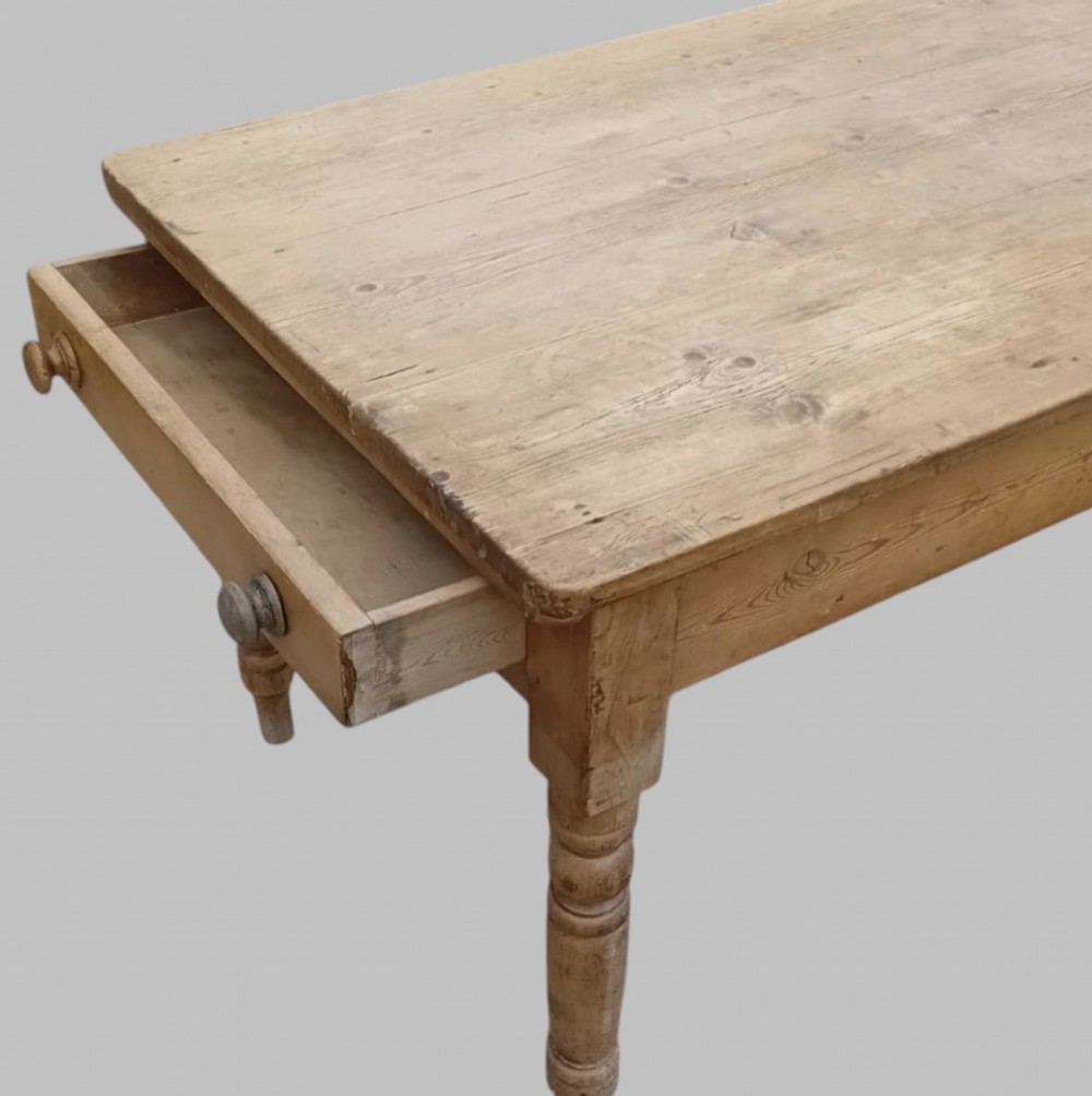 A late 19th-century rectangular pine farmhouse table featuring a scrubbed wood plank top, a frieze drawer with turned wooden knobs, and turned legs. View V