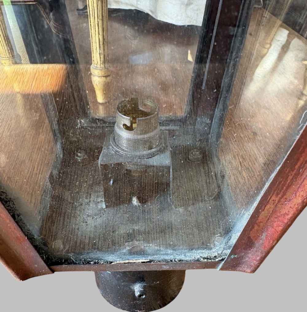 A pair of tapered copper post lanterns featuring clear glass side panels, cylindrical top chimneys, corner fins, and black collar mounts. View V