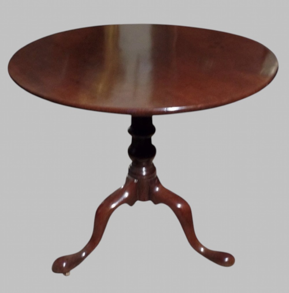A Georgian mahogany tilt-top occasional table featuring a circular surface supported by a turned pedestal stem and tripod cabriole legs.