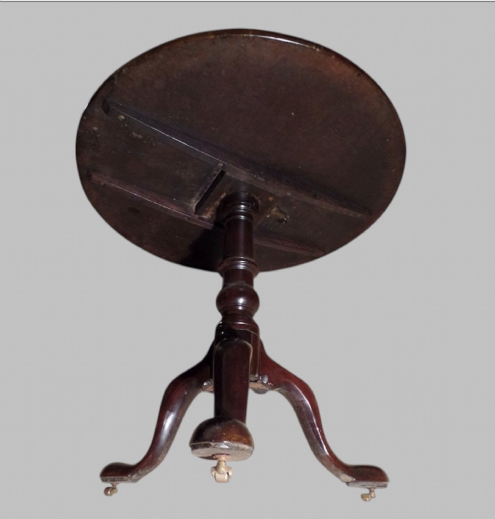A Georgian mahogany tilt-top occasional table featuring a circular surface supported by a turned pedestal stem and tripod cabriole legs. View II
