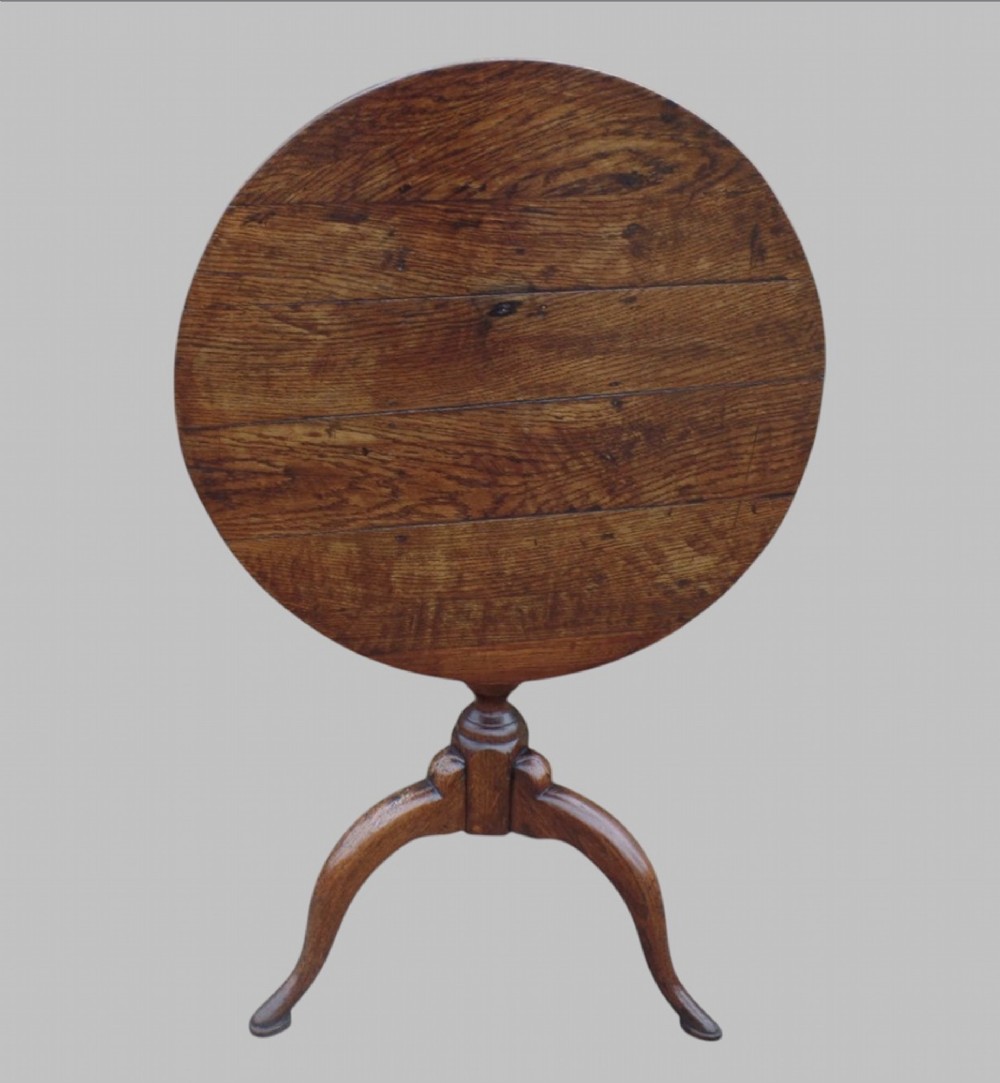 A circular George III country oak tripod table with a turned central column and three curved legs. View II