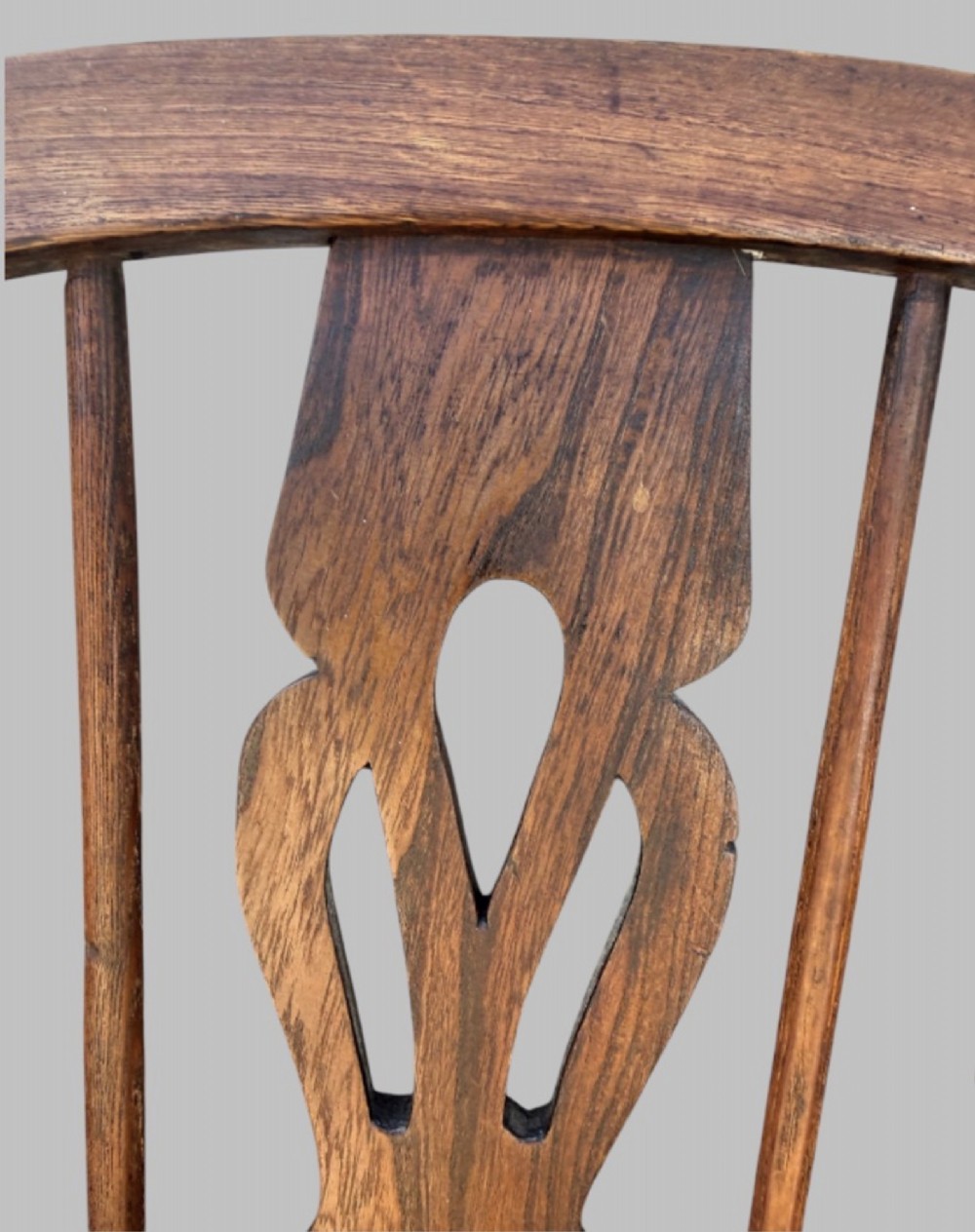 A nineteenth-century hoop-back Windsor armchair crafted from ash and elm wood, featuring a shaped saddle seat, pierced splat, slender back spindles, turned front legs, and an H-stretcher. View V