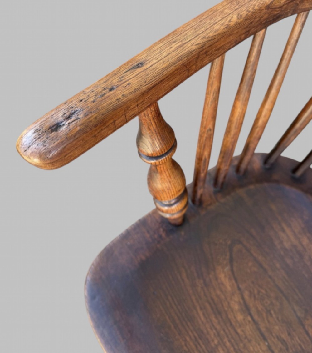 A nineteenth-century hoop-back Windsor armchair crafted from ash and elm wood, featuring a shaped saddle seat, pierced splat, slender back spindles, turned front legs, and an H-stretcher. View VII