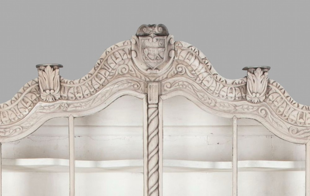 A tall nineteenth-century Dutch carved pale oak display cabinet featuring a shaped crest, multi-pane glazed upper doors, and a bombe chest base with three relief-carved drawers on paw feet. View VIII