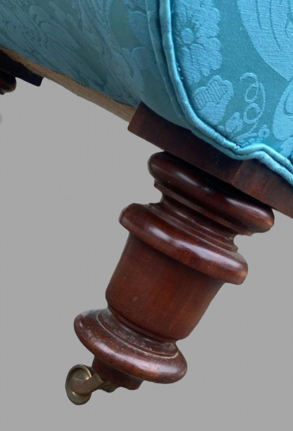 A 19th-century French lit bateau daybed upholstered in light blue damask fabric with outward-scrolled ends and dark turned timber feet. View V