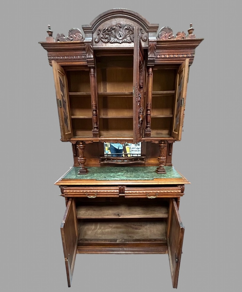 A late 19th-century French Provincial walnut dresser featuring hand-carved relief panels, glazed side cabinets, turned support columns, and a green marble insert surface. View II