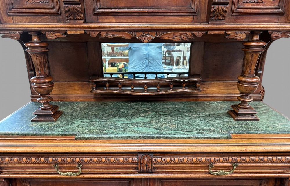 A late 19th-century French Provincial walnut dresser featuring hand-carved relief panels, glazed side cabinets, turned support columns, and a green marble insert surface. View VI