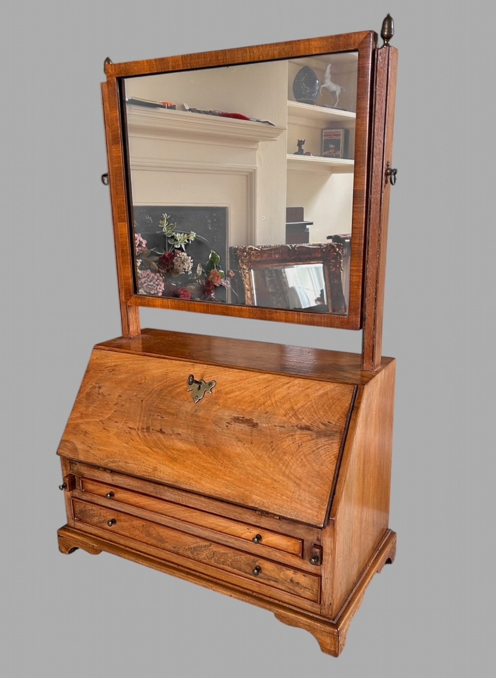 An Edwardian satinwood tabletop bureau featuring a slant-front writing slope over small drawers, topped with a rectangular swivel dressing mirror.