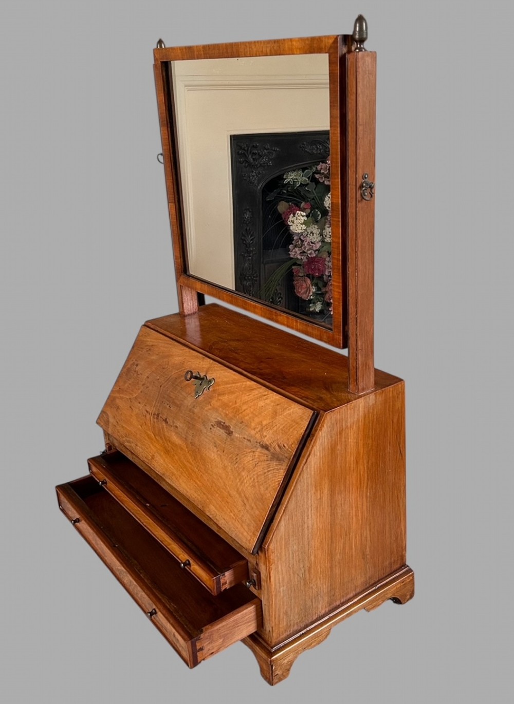 An Edwardian satinwood tabletop bureau featuring a slant-front writing slope over small drawers, topped with a rectangular swivel dressing mirror. View IV