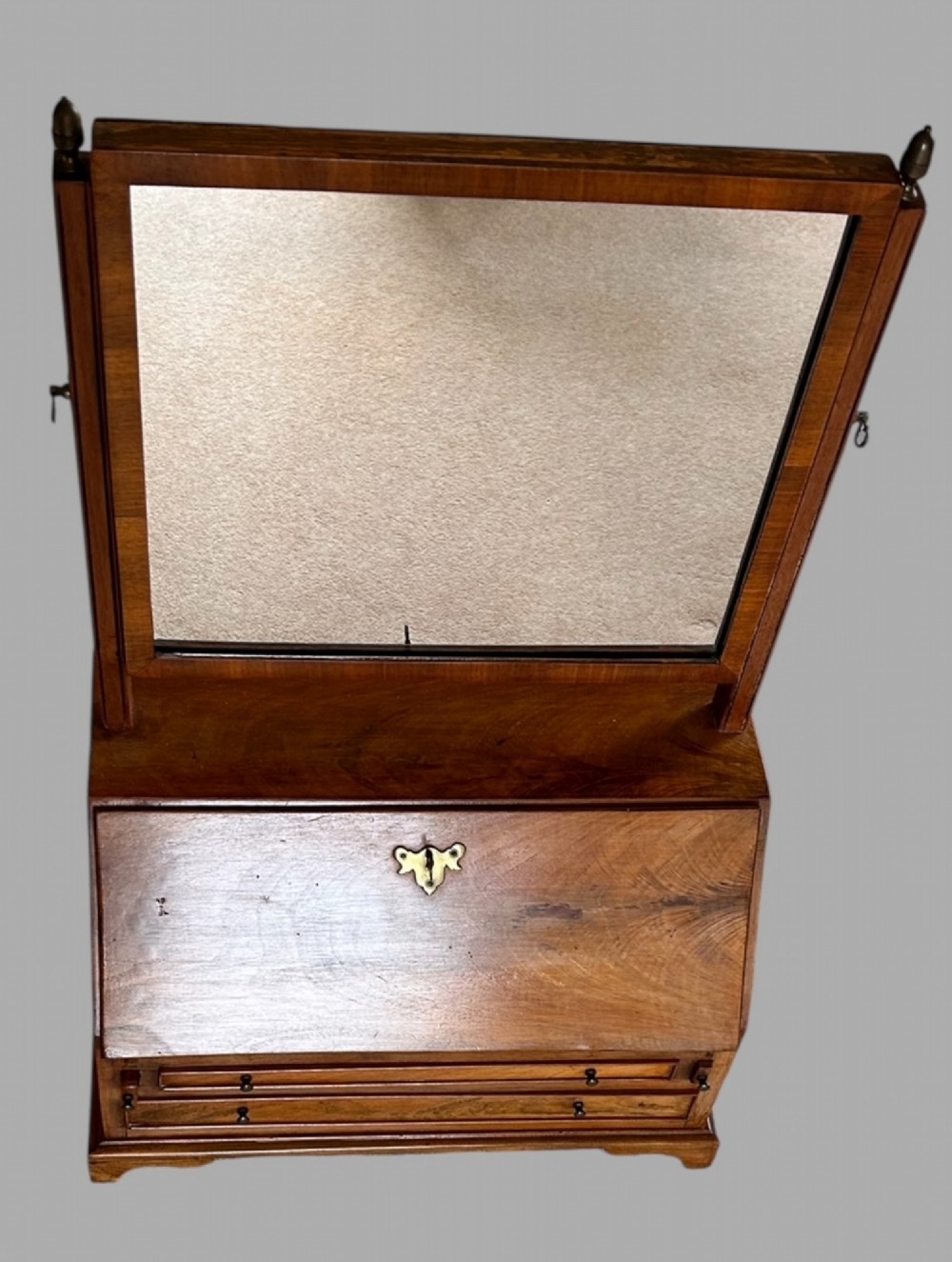 An Edwardian satinwood tabletop bureau featuring a slant-front writing slope over small drawers, topped with a rectangular swivel dressing mirror. View V