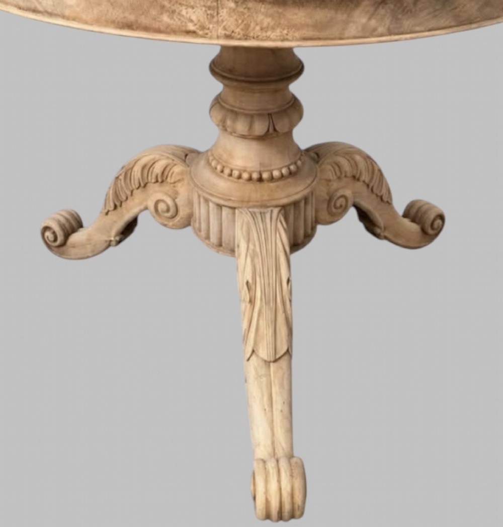 A circular antique French gueridon table featuring a dark grey mottled marble top supported by a carved bleached walnut pedestal and tripod scrolled legs. View III