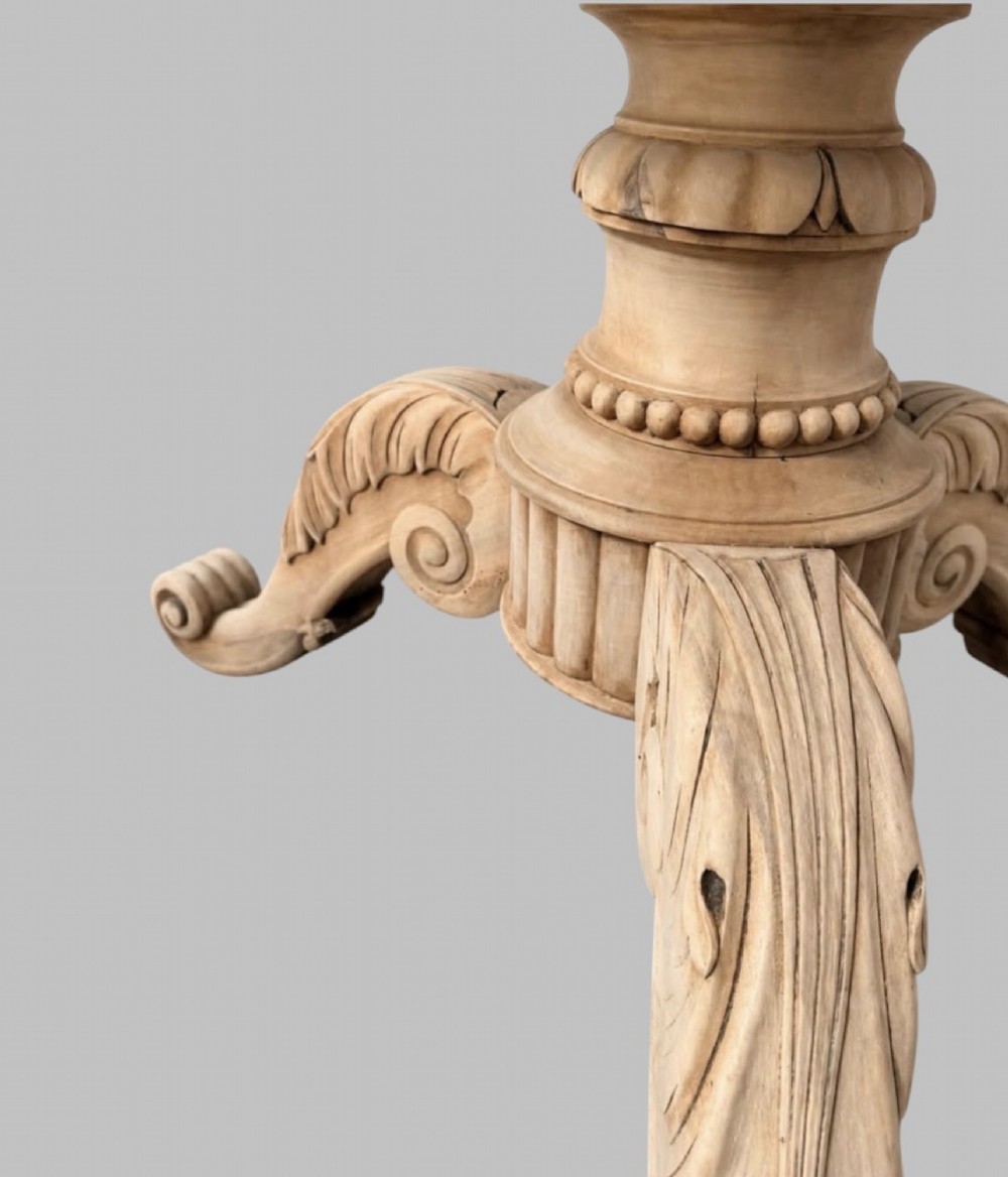 A circular antique French gueridon table featuring a dark grey mottled marble top supported by a carved bleached walnut pedestal and tripod scrolled legs. View V