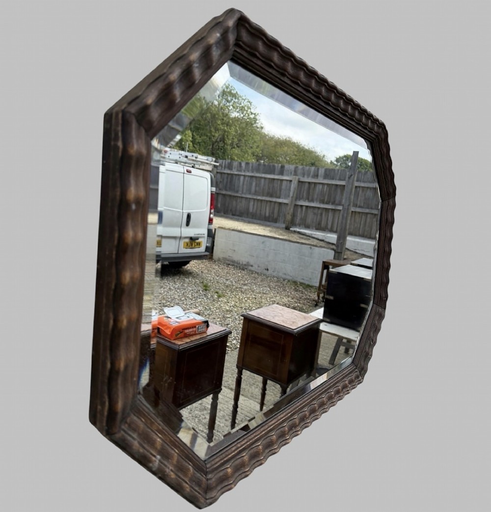 An octagonal early 20th-century wall mirror featuring a dark reeded wooden frame and a central bevelled glass plate. View II