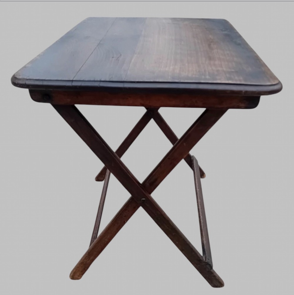 An early twentieth-century dark stained beech folding table featuring a rectangular top with rounded corners and collapsible wooden legs. View II