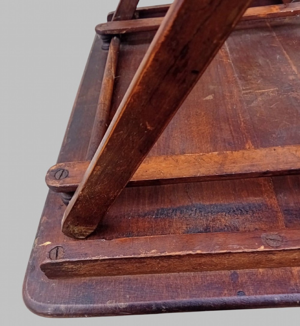 An early twentieth-century dark stained beech folding table featuring a rectangular top with rounded corners and collapsible wooden legs. View IV