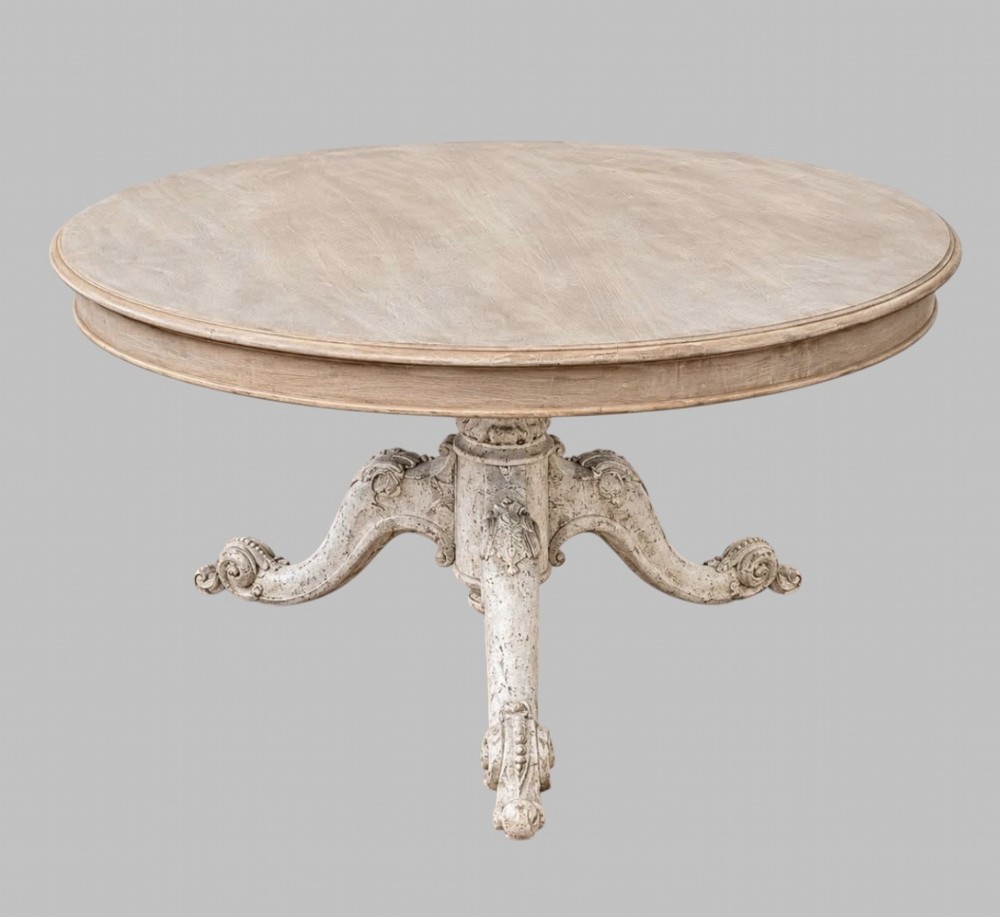 A circular mid-19th-century centre table featuring a bleached mahogany top supported by a carved tripod pedestal base.