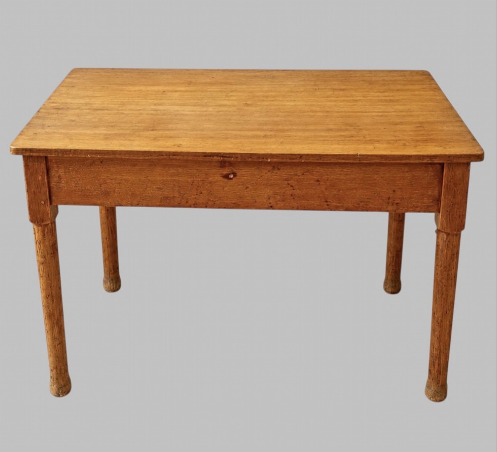 An early 20th-century light oak work table featuring a rectangular top, two frieze drawers with brass cup handles, and turned legs. View III