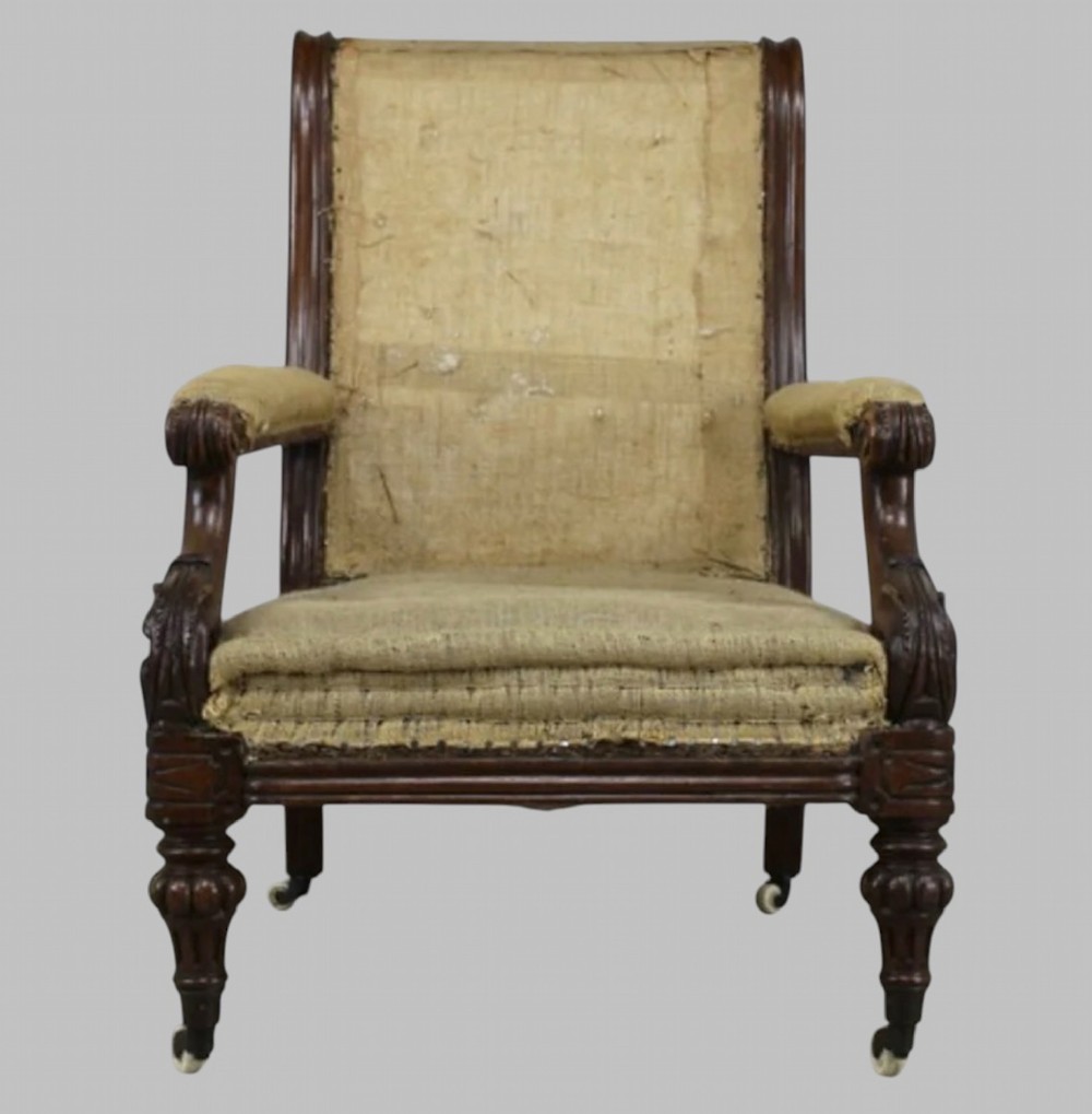 Side profile of a William IV carved oak armchair with upholstered seat, scrolled arms, turned front legs, and castors. View II