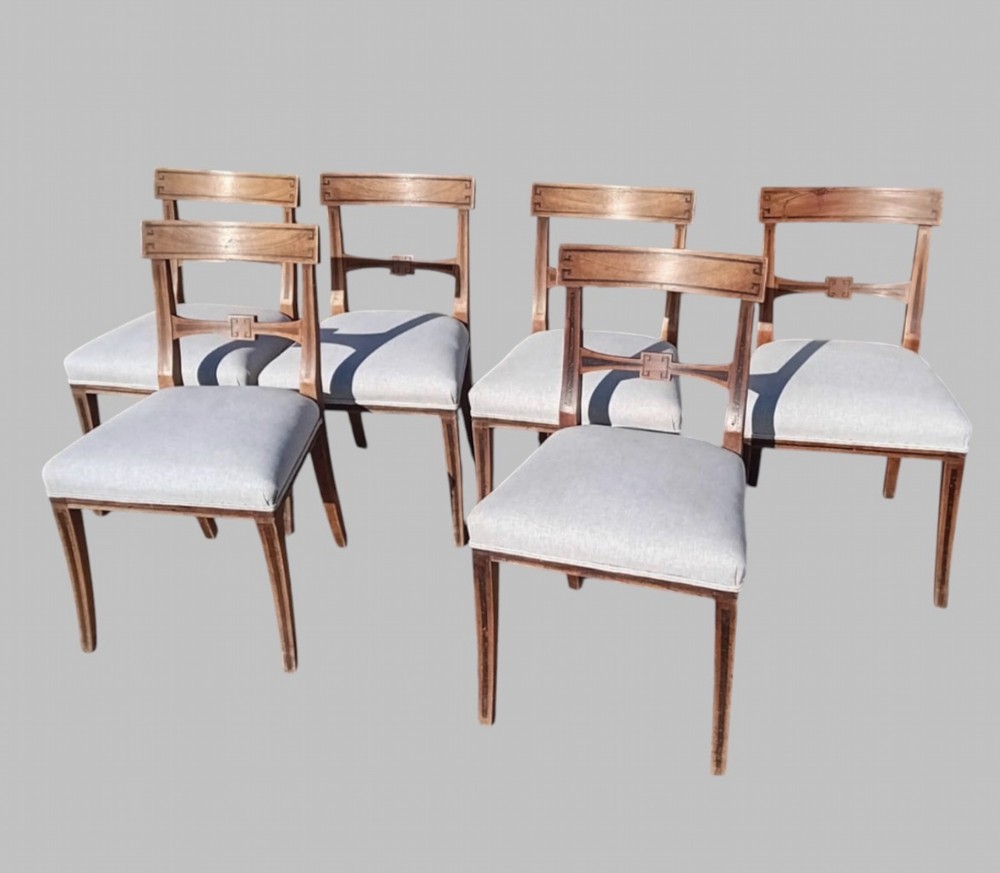 A set of six late 19th-century mahogany dining chairs with geometric marquetry inlay and light grey upholstered seats.