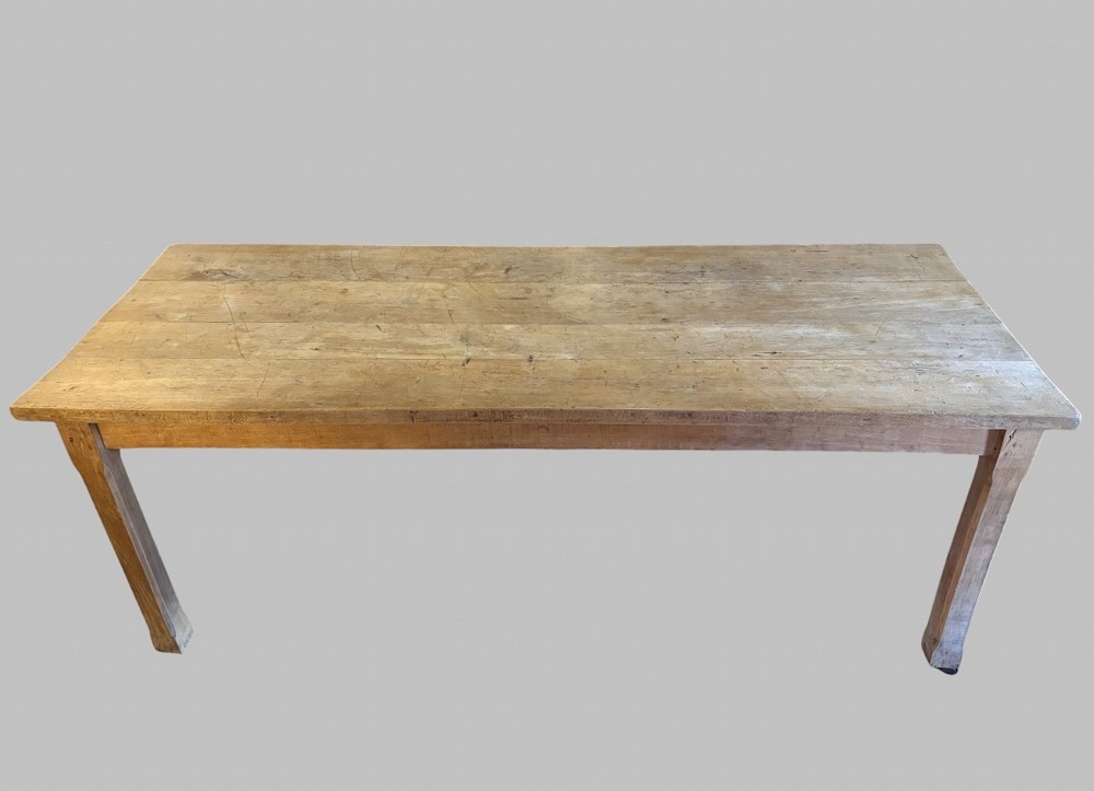 A 19th-century rectangular elm farmhouse table featuring a multi-plank top, straight aprons, four square tapering legs, and small metal castors. View II