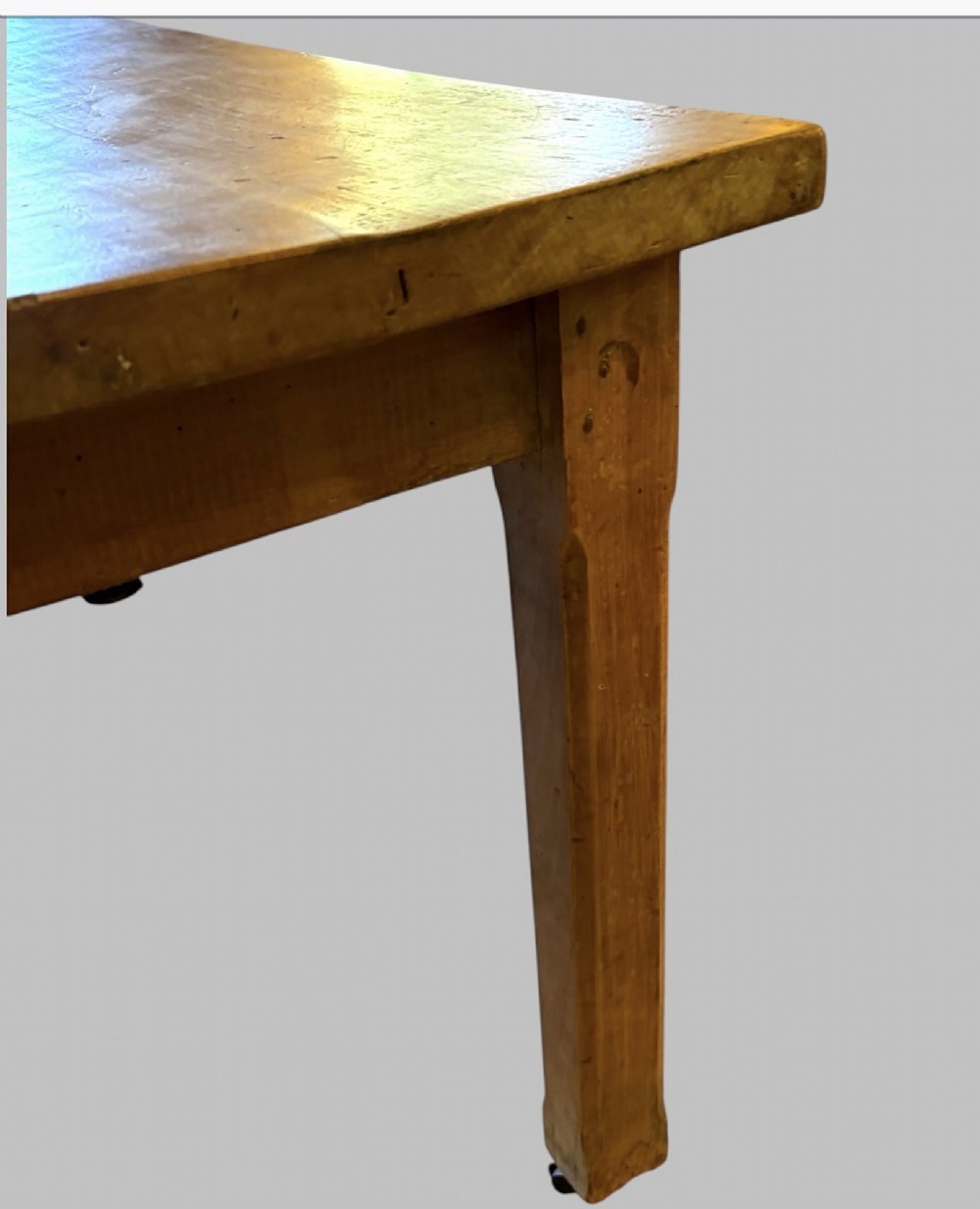 A 19th-century rectangular elm farmhouse table featuring a multi-plank top, straight aprons, four square tapering legs, and small metal castors. View V