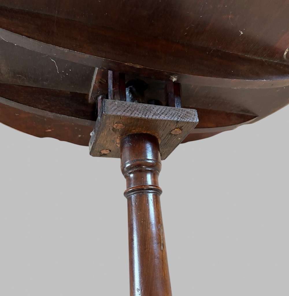 A dark mahogany tripod table featuring a circular pie-crust scalloped top, a turned central column with a birdcage block, and three cabriole legs ending in pad feet. View VI