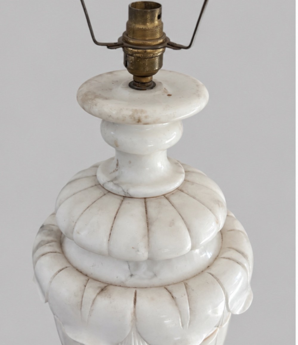 A carved off-white alabaster table lamp base shaped like a classical urn with leaf motifs, resting on a stepped square plinth with a brass harp socket. View III