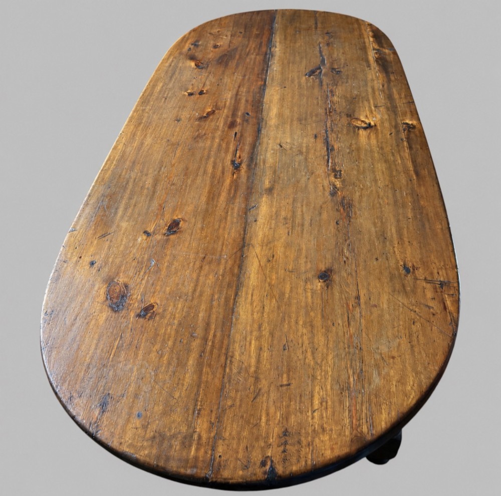 An antique Swedish provincial pine farmhouse table featuring an oval plank top, frieze with drawer moulding, turned baluster legs, and a low rectangular box stretcher. View III