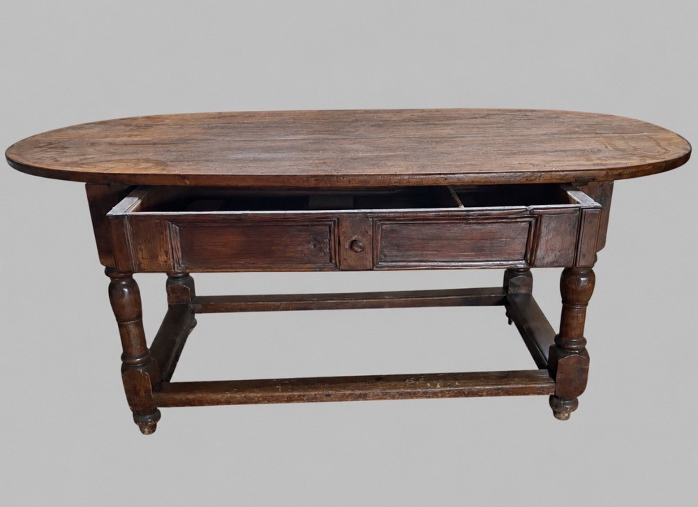 An antique Swedish provincial pine farmhouse table featuring an oval plank top, frieze with drawer moulding, turned baluster legs, and a low rectangular box stretcher. View IV