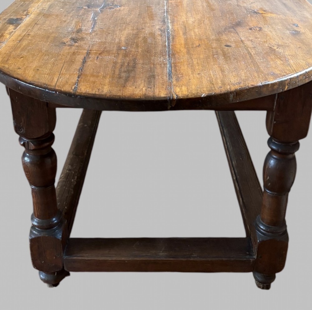 An antique Swedish provincial pine farmhouse table featuring an oval plank top, frieze with drawer moulding, turned baluster legs, and a low rectangular box stretcher. View VI