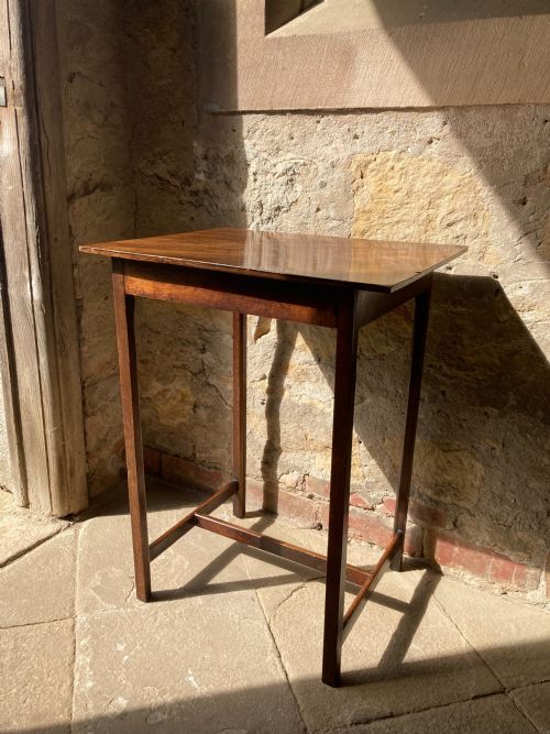 fig 1. A Regency period mahogany occasional table featuring a rectangular polished top, straight legs, and lower H-stretchers.