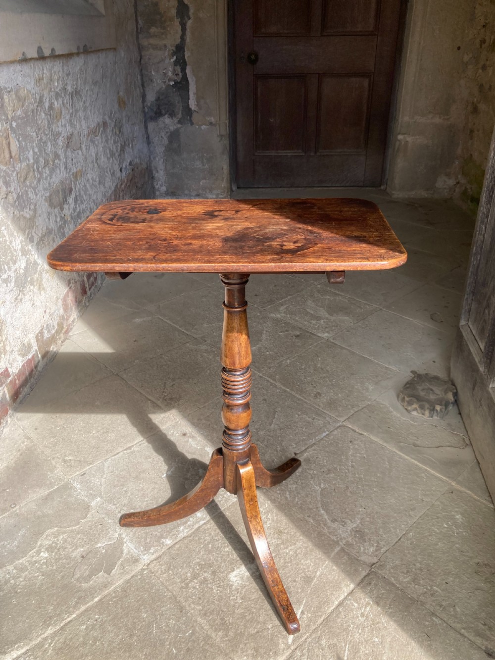 A Regency mahogany tripod table featuring a rectangular surface with rounded corners, a central turned stem, and three splayed legs. View II