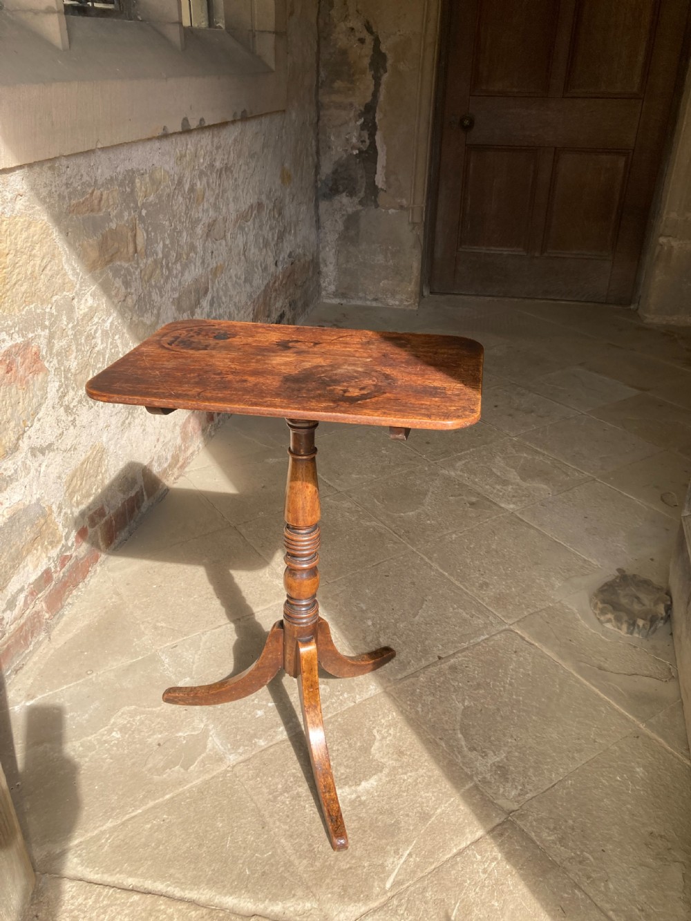 A Regency mahogany tripod table featuring a rectangular surface with rounded corners, a central turned stem, and three splayed legs. View III