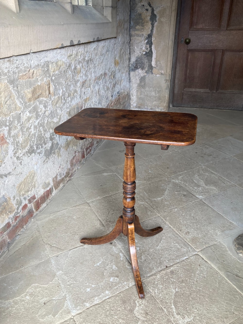 A Regency mahogany tripod table featuring a rectangular surface with rounded corners, a central turned stem, and three splayed legs. View IX