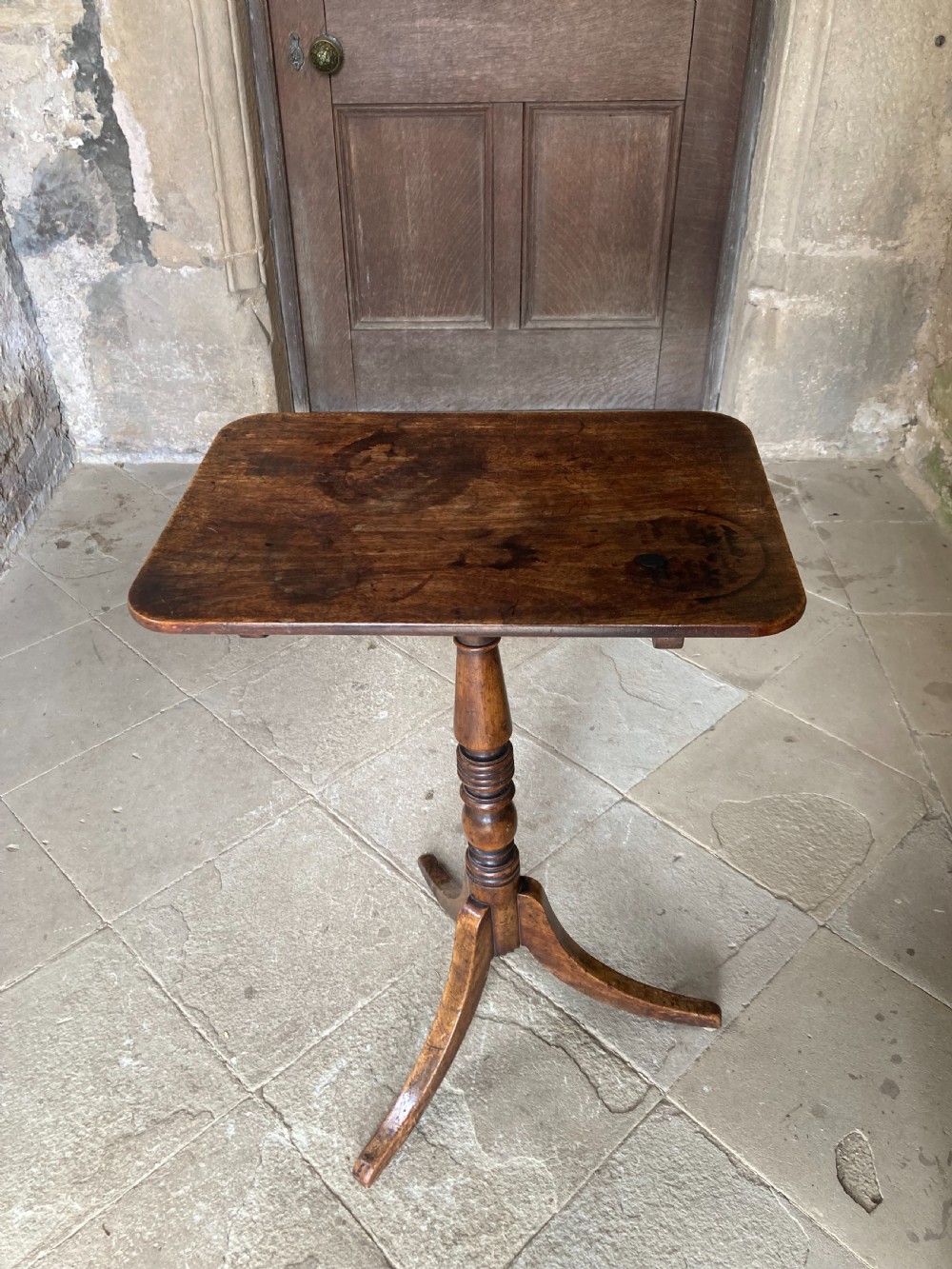 A Regency mahogany tripod table featuring a rectangular surface with rounded corners, a central turned stem, and three splayed legs. View XI