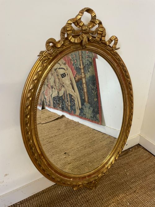 Oval Gilt Mirror with Ribbon Scrolls 
